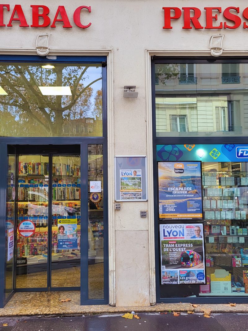 Façade d’un tabac-presse avec enseigne et affiches en vitrine
